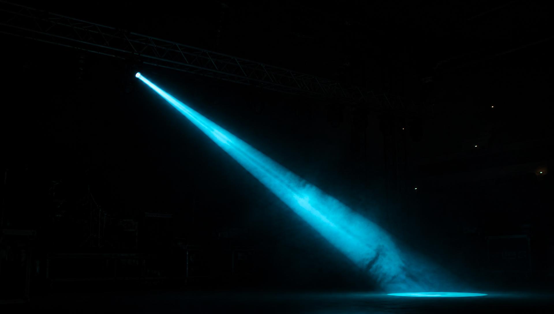 Stage beams cutting through haze at soundcheck
